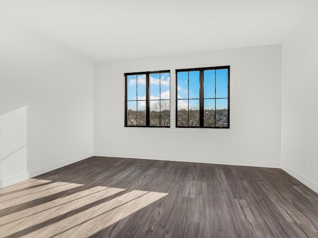 unfurnished room with dark hardwood / wood-style flooring