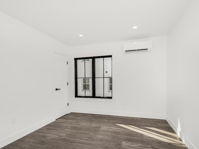 unfurnished room featuring dark hardwood / wood-style floors and an AC wall unit