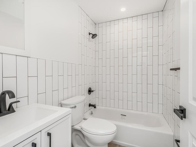 full bathroom featuring toilet, tiled shower / bath combo, sink, and tile walls