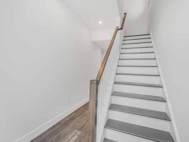 staircase with hardwood / wood-style floors