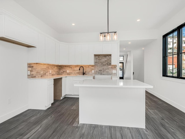 kitchen featuring white cabinetry, tasteful backsplash, a kitchen island, and pendant lighting