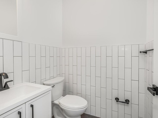 bathroom featuring sink, tile walls, and toilet