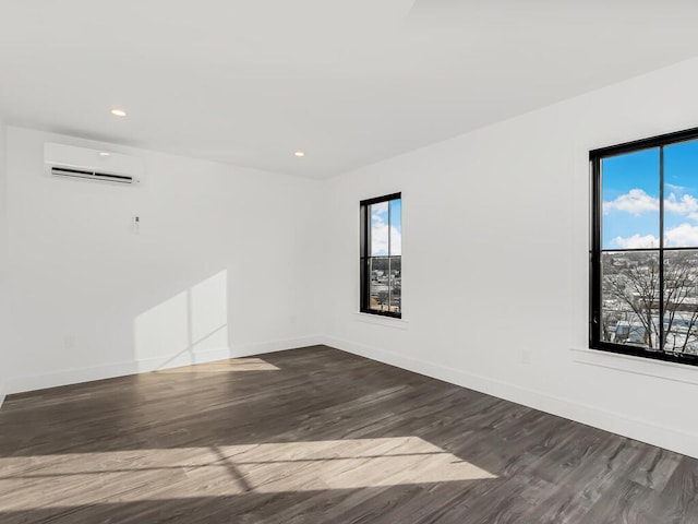 spare room with hardwood / wood-style floors and an AC wall unit