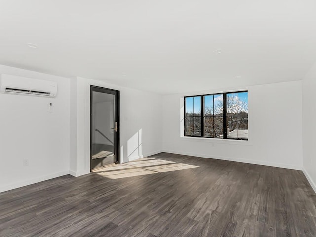 unfurnished room with dark hardwood / wood-style floors and a wall mounted AC