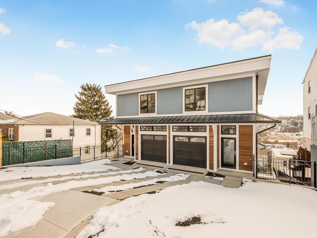 snow covered back of property with a garage