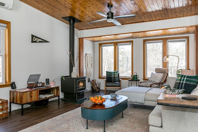 living room with wooden ceiling, dark hardwood / wood-style floors, a wealth of natural light, and a wood stove