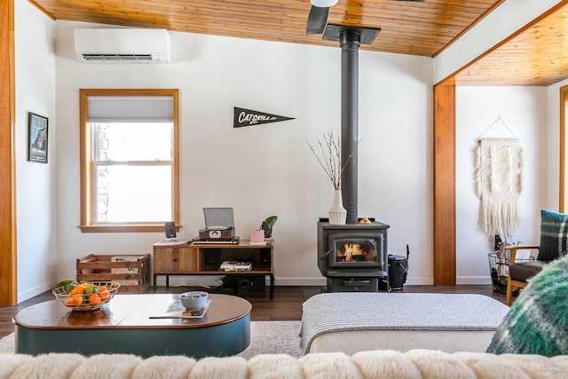 living room featuring dark hardwood / wood-style flooring, an AC wall unit, a wood stove, and wood ceiling