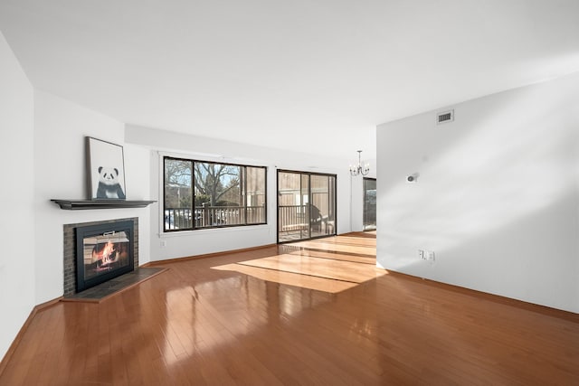 unfurnished living room featuring hardwood / wood-style flooring and a notable chandelier