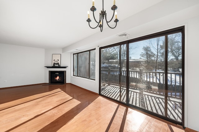 interior space with a fireplace, hardwood / wood-style floors, and a notable chandelier