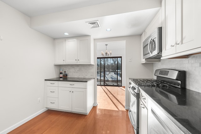 kitchen with white cabinetry, stainless steel appliances, and light wood-type flooring