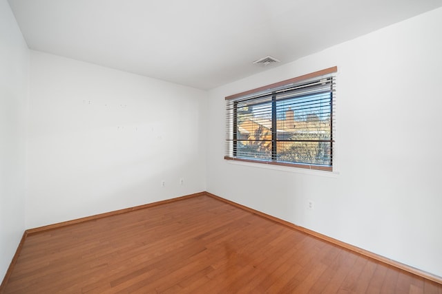 unfurnished room with hardwood / wood-style flooring