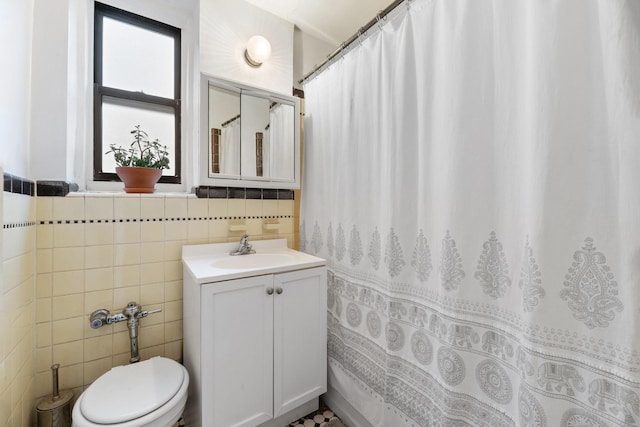 bathroom with tile walls, vanity, and toilet