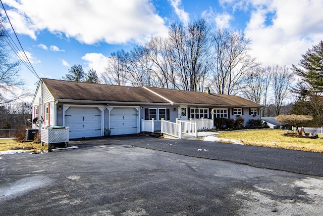 ranch-style home featuring central AC, a garage, and a front yard