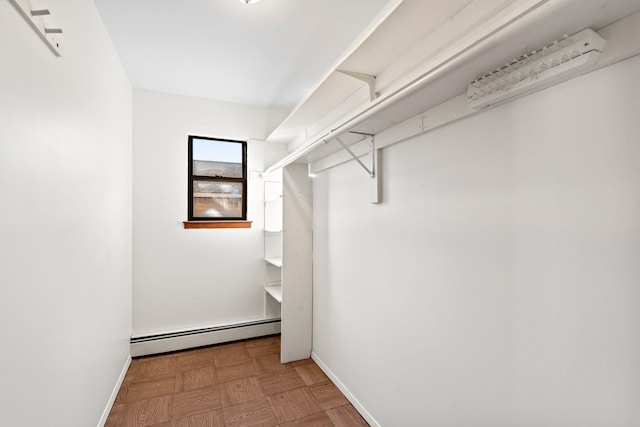 walk in closet featuring baseboard heating and parquet flooring