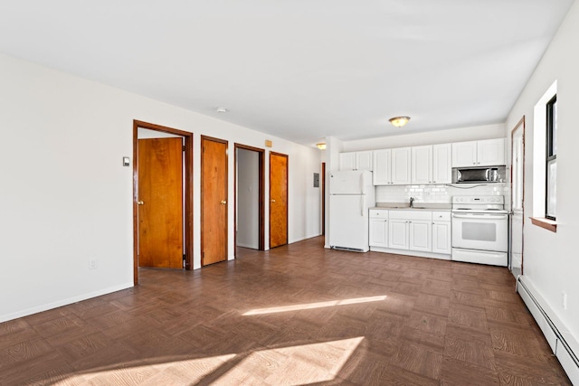 kitchen with white appliances, a baseboard heating unit, dark parquet floors, white cabinets, and decorative backsplash