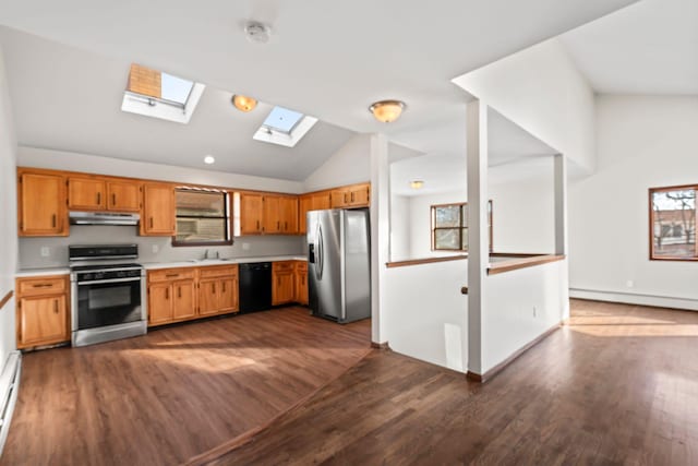 kitchen with dark wood-type flooring, lofted ceiling with skylight, sink, baseboard heating, and appliances with stainless steel finishes