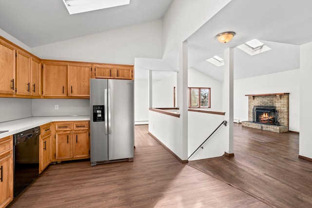 kitchen with lofted ceiling with skylight, dark hardwood / wood-style floors, black dishwasher, and stainless steel refrigerator with ice dispenser