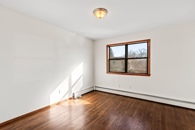 empty room featuring hardwood / wood-style flooring and baseboard heating