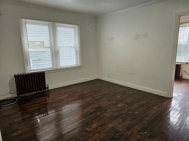 spare room with crown molding, radiator, and dark hardwood / wood-style flooring