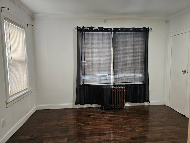 spare room with crown molding, radiator heating unit, and dark hardwood / wood-style floors