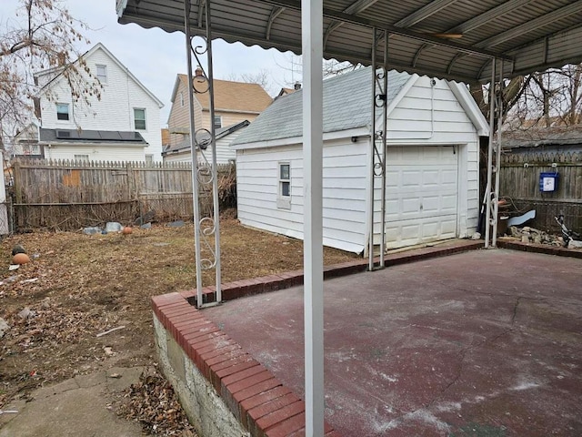 view of patio / terrace featuring a garage and an outbuilding