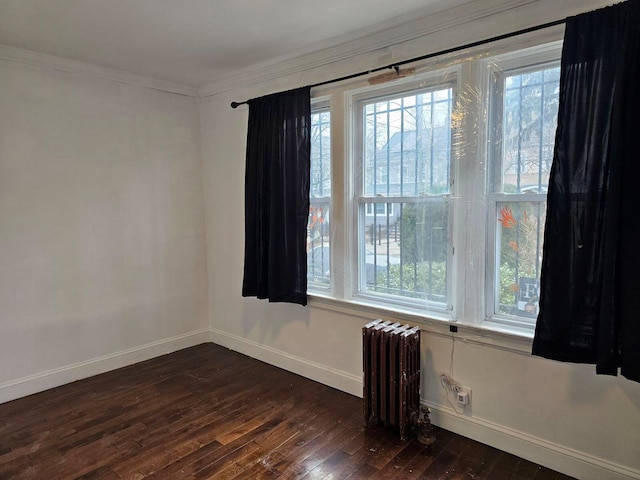 unfurnished room featuring crown molding, radiator, and dark wood-type flooring