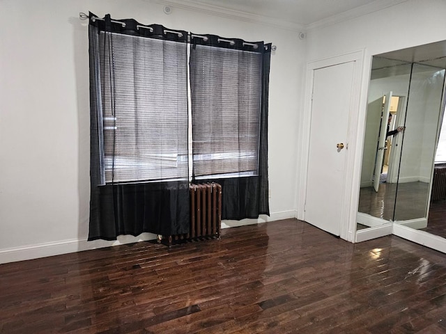 unfurnished room featuring dark wood-type flooring, ornamental molding, and radiator heating unit