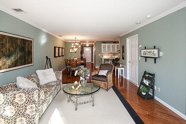 living room featuring wood-type flooring and ornamental molding