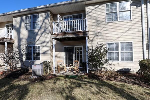 back of house with a yard, central AC, and a balcony