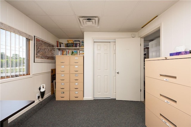 interior space with dark carpet and a drop ceiling