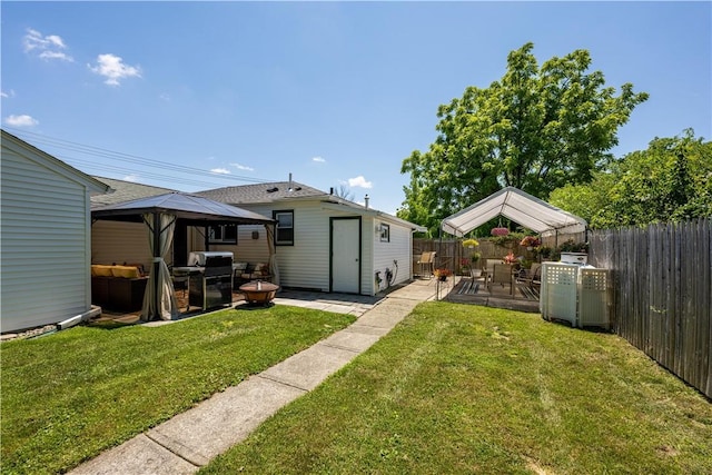 back of house featuring a gazebo, an outdoor structure, and a lawn