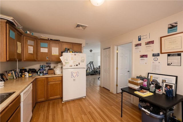 kitchen featuring white appliances and light hardwood / wood-style flooring