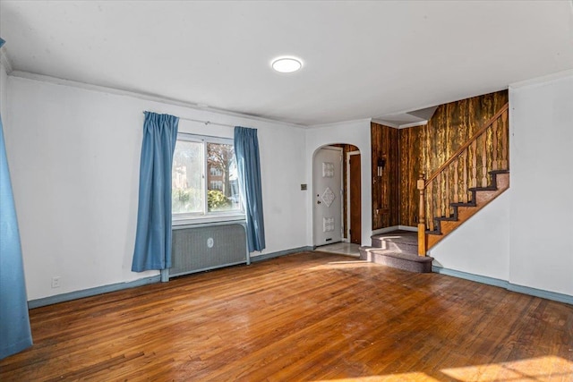 spare room featuring hardwood / wood-style flooring, ornamental molding, and radiator heating unit