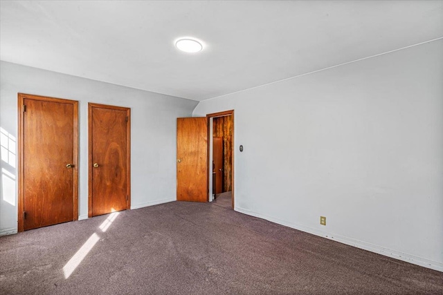 unfurnished bedroom with multiple closets and carpet