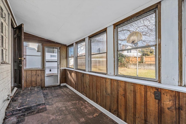 unfurnished sunroom featuring vaulted ceiling