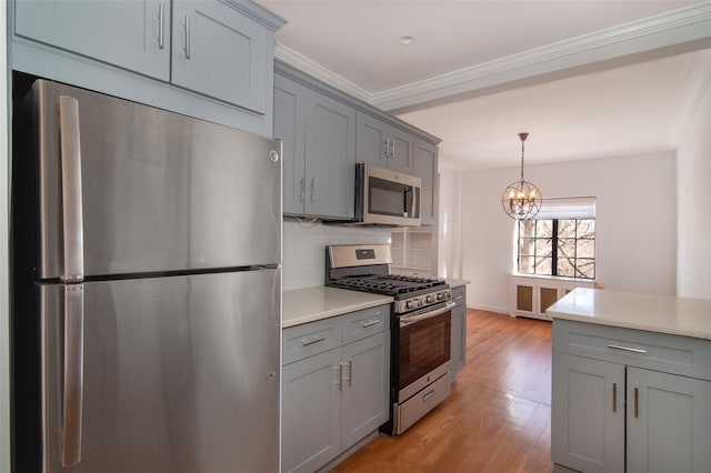 kitchen featuring gray cabinetry, stainless steel appliances, tasteful backsplash, ornamental molding, and light wood-type flooring