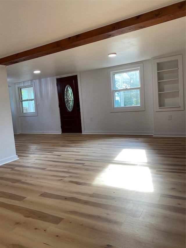 foyer entrance with beamed ceiling and light hardwood / wood-style flooring