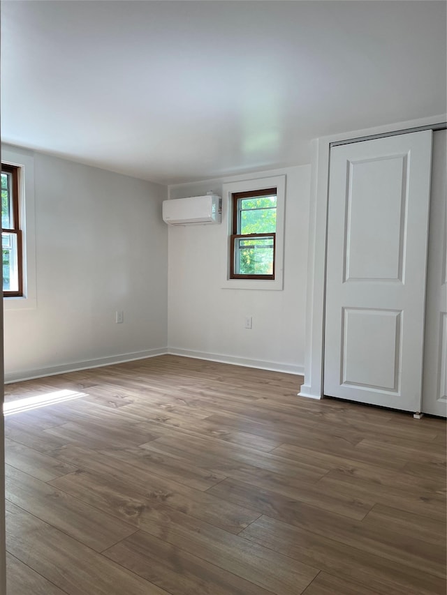 spare room featuring dark hardwood / wood-style floors and an AC wall unit