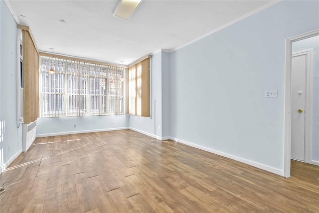 empty room featuring hardwood / wood-style flooring and ornamental molding