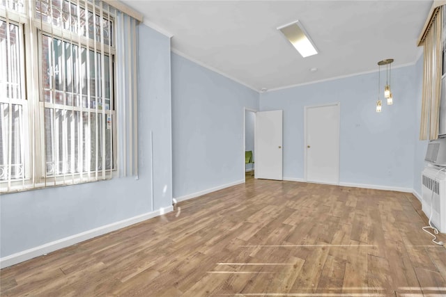 unfurnished living room featuring radiator, hardwood / wood-style flooring, and ornamental molding