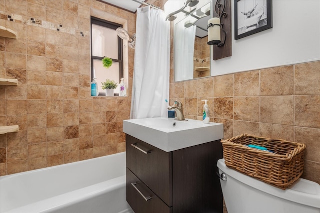 full bathroom with shower / bathtub combination with curtain, vanity, toilet, and tile walls