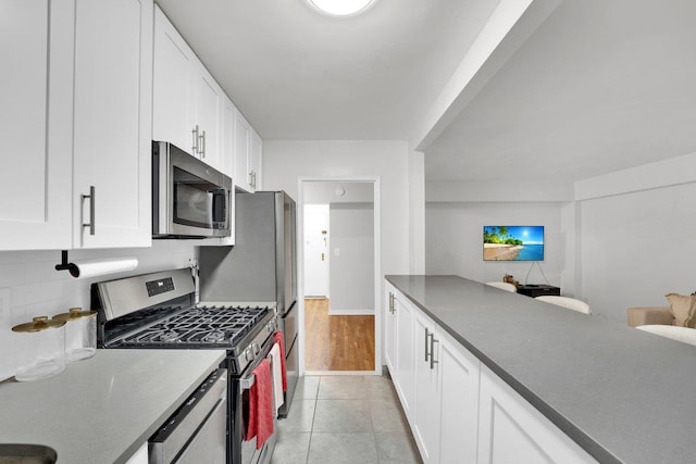 kitchen with white cabinetry, appliances with stainless steel finishes, and light tile patterned floors