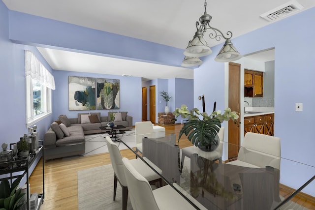 dining space with sink and light hardwood / wood-style flooring