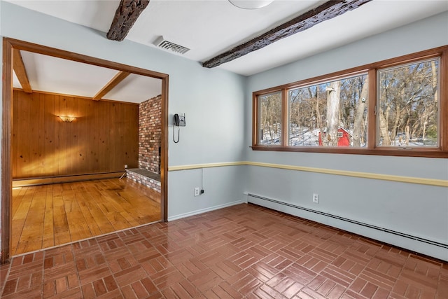 empty room with beamed ceiling, a baseboard heating unit, and a wealth of natural light