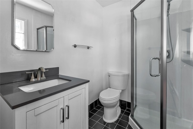 bathroom with vanity, toilet, tile patterned floors, and walk in shower