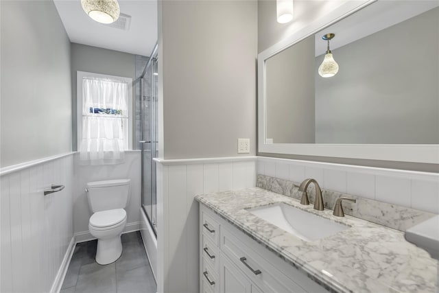 full bathroom featuring vanity, tile patterned flooring, combined bath / shower with glass door, and toilet