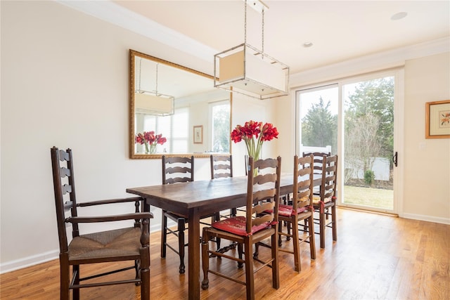 dining area featuring hardwood / wood-style floors and crown molding