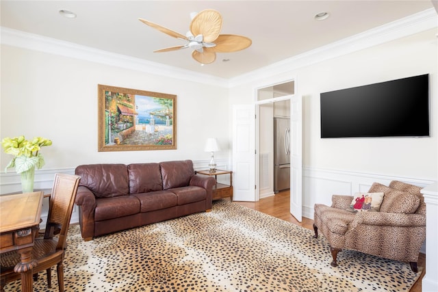 living room with light hardwood / wood-style flooring, ornamental molding, and ceiling fan