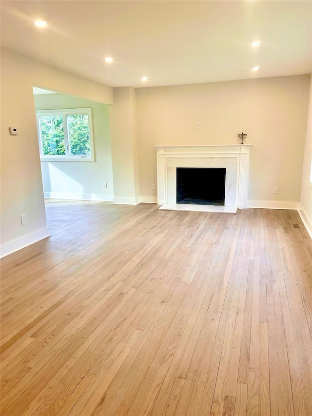 unfurnished living room with light hardwood / wood-style flooring and a premium fireplace