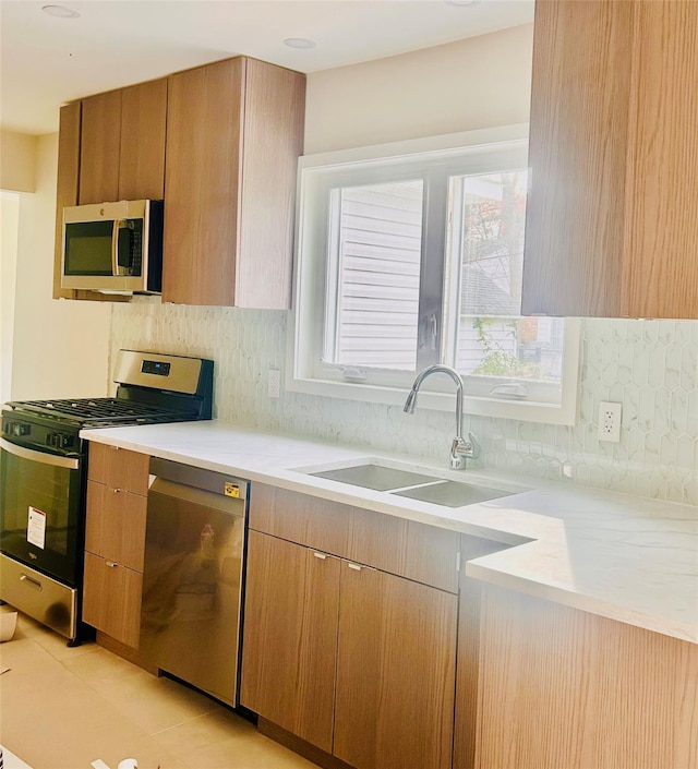 kitchen with sink, decorative backsplash, and stainless steel appliances